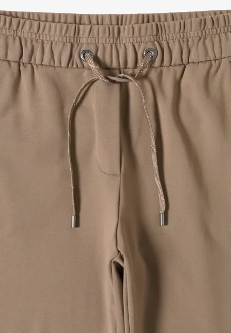 Beigefarbene Jogginghose mit Kordelzug am Bund.